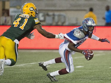 Montreal Alouettes' Rakeem Cato, right, has his jersey pulled on by Edmonton Eskimos' Odell Willis during first half CFL football action in Montreal on Thursday, August 13, 2015.