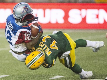 Montreal Alouettes' Rakeem Cato, left, is tackled by Edmonton Eskimos' Odell Willis during first half CFL football action in Montreal on Thursday, August 13, 2015.