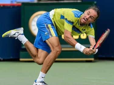 Alexandr Dolgopolov of Ukraine hits a return against Grigor Dimitrov of Bulgaria during day two of the Rogers Cup at Uniprix Stadium on August 11, 2015 in Montreal, Quebec, Canada.