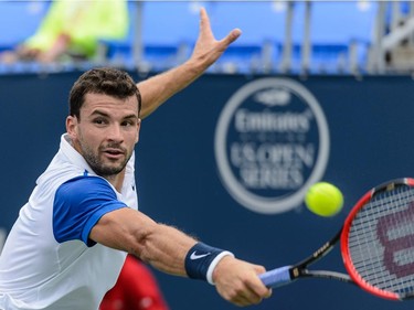 Grigor Dimitrov of Bulgaria hits a return against Alexandr Dolgopolov of Ukraine during day two of the Rogers Cup at Uniprix Stadium on August 11, 2015 in Montreal, Quebec, Canada.