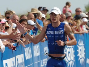 In this Aug. 10, 2014, file photo, Lionel Sanders, from heads toward the finish line as he wins the men's pro division of the Maytag Steelhead Ironman 70.3 Triathlon race in Benton Harbor, Mich.