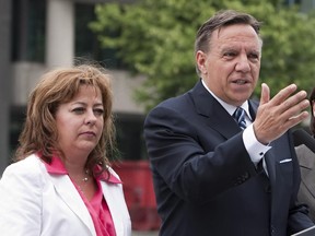 In this file photo, Sylvie Roy (left) listens as Coalition Avenir Quebec leader Francois Legault speaks about stamping out corruption on Thursday Aug. 2, 2012 in Quebec City. Roy died Sunday, July 31, 2016.
