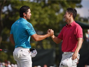 Jason Day of Australia, left, and Sang-Moon Bae of Korea shake hands on the18th green during the third round of The Barclays at Plainfield Country Club on August 29, 2015 in Edison, N.J.