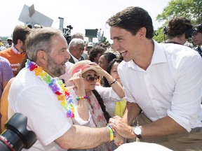 Liberal Leader Justin Trueau, right, greets NDP Leader Thomas Mulcair during a federal election campaign stop at the annual gay pride parade in Montreal, Sunday, August 16, 2015.
