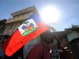 A man holds a Haitian flag in Port-au-Prince on January 13, 2014.