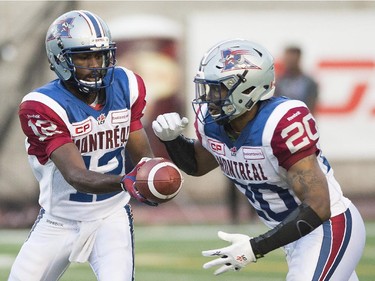 Montreal Alouettes' Rakeem Cato, left, hands off to teammate Tyrell Sutton during first half CFL football action against the Edmonton Eskimos in Montreal on Thursday, August 13, 2015.