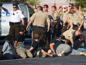 Demonstrators are arrested during a civil disobedience action August 10, 2015 on US Interstate 70 in Earth City, Missouri.  St. Louis County declared a state of emergency Monday following a night of unrest in Ferguson, after a teenager was charged with shooting at police officers.