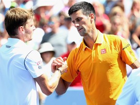 Novak Djokovic of Serbia shakes hands with David Goffin of Belarus after their match during Day 6 of the Western and Southern Open at the Lindner Family Tennis Center on August 20, 2015 in Cincinnati, Ohio.