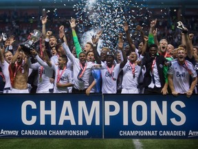 Vancouver Whitecaps players hoist the Voyageurs Cup trophy after defeating the Montreal Impact to win the Canadian Championship final soccer action in Vancouver, B.C., on Wednesday August 26, 2015.