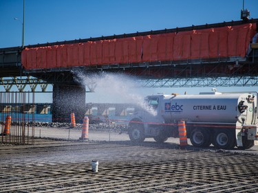 A water vehicle waters fresh cement on what will become a foundation for a pillar in the new Champlain as it sits on a jetty in Montreal on Friday, September 4, 2015.