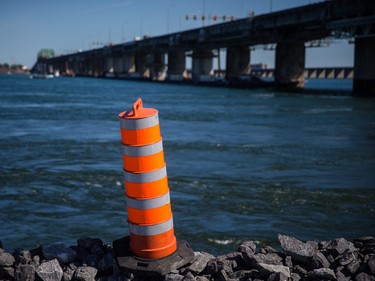 A construction cone sits on the end of a jetty which will be used for construction in the new Champlain bridge as the old Champlain bridge is seen in the background in Montreal on Friday, September 4, 2015.