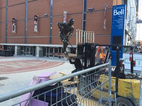 Workers prepare to install a statue in the new plaza next to the Bell Centre on Tuesday, Sept. 22, 2015.