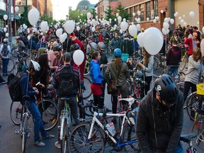 Hundreds of people turned out for the occasion Friday, Sept. 26, 2015, as a bicycle painted entirely in white was attached to a light pole on St-Denis St., close to the Jean-Talon métro station, to mark the location where Bernard Carignan was killed on Aug. 22. Carignan was cycling along the street when his bicycle struck the door of a vehicle that had swung open while parked on the street.