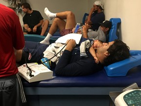 Montreal Canadiens forward Max Pacioretty lies in a Florida clinic on July 9, 2015, with his year-and-and-half-old son, Enzo, on his chest. In this photo, Pacioretty is being treated after having suffered left tibia plateau fractures, at this time not yet known, a half-hour earlier while training off-ice.