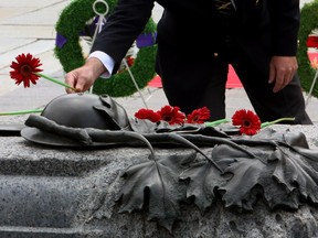 A flower is placed on the Tomb of the unknown Soldier during a commemoration ceremony of the 70th anniversary of the end of the Second World War in the Far East, or V-J Day (Victory Over Japan) at the National War Memorial in Ottawa on Saturday, August 15, 2015.