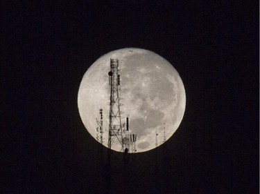 A full moon silhouettes television and radio antennas on Boutilier Mountain, in Port-au-Prince, Haiti, early Sunday, Sept. 27, 2015.