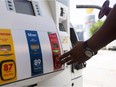 A man prepares to fill his car's gas tank in Toronto.