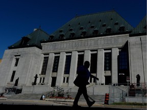 A pedestrian walks past the Supreme Court of Canada in Ottawa on Thursday, July 23, 2015.