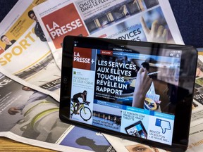 A tablet is seen on the paper edition of La Presse Wednesday, September 16, 2015 in Montreal. The Montreal-based daily newspaper announced that it will scrap its print edition from Monday to Friday starting in January 1, 2016.