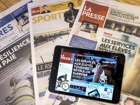 A tablet is seen on the paper edition of La Presse.