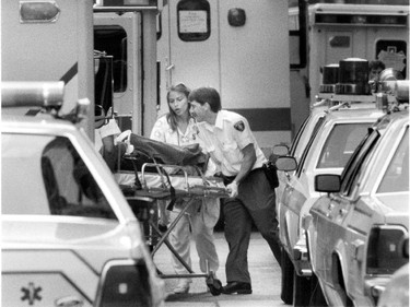 Ambulance attendants wheel an unidentified person to an ambulance after the deadly shooting spree by Valery Fabrikant on August 24, 1992.