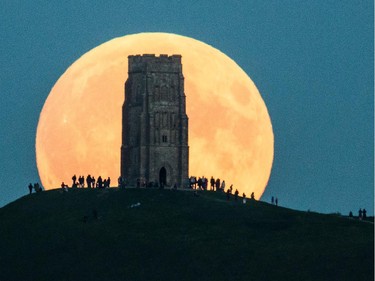 The supermoon rises behind Glastonbury Tor on Sept. 27, 2015. in Glastonbury, England. The supermoon, so called because it is the closet full moon to the Earth this year, is particularly rare as it coincides with a lunar eclipse, a combination that has not happened since 1982 and won't happen again until 2033.