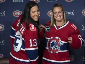 Caroline Ouellette, left, and Marie-Philip Poulin show of their team's new jersey Thursday, September 24, 2015, in Montreal. The CWHL Montreal-based franchise has also been renamed to become Les Canadiennes.