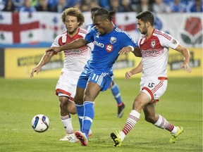The Impact's Didier Drogba, centre, challenges D.C. United's Nick DeLeon, left, and Steve Birnbaum during MLS game at Montreal's Saputo Stadium on Sept. 26, 2015.