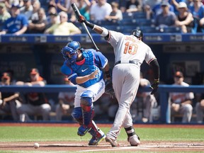 Toronto Blue Jays catcher Dioner Navarro, left, pushes Baltimore Orioles' Adam Jones to get the ball after Jones struck out during first inning MLB baseball action in Toronto on Sunday, September 6, 2015.