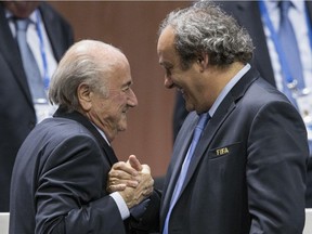 In this May 29, 2015, file photo, FIFA president Sepp Blatter after his election as president, left, is greeted by UEFA president Michel Platini  at the Hallenstadion in Zurich. On Friday, Sept. 25, 2015, the Swiss attorney general opened criminal proceedings against Blatter.