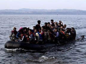 Refugees and migrants arrive on the shores of the Greek island of Lesbos after crossing the Aegean Sea from Turkey on an inflatable boat on September 9, 2015. Overwhelmed by the 20,000 refugees and migrants currently camped on the holiday island, authorities hastily set up a refugee registration centre September 8 on a parched old football pitch. Local authorities have found it impossible to keep up with the pace of the influx, and tensions have boiled over.