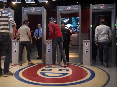 Hockey fans make their way through metal detectors at the Bell Centre, in Montreal, where the Montreal Canadiens will face the Toronto Maple Leafs in pre-season action on Tuesday, September 22, 2015. The new security system is part of a League-wide effort to standardize attendee screening.