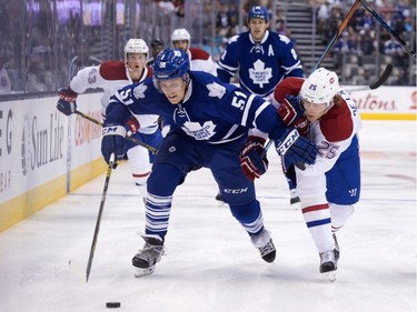 Toronto Maple Leafs defenceman Jake Gardiner, left, fights for the puck with Montreal Canadiens forward Jacob De La Rose during first period pre-season exhibition NHL hockey action in Toronto on Saturday, September 26, 2015.
