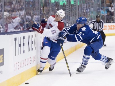Toronto Maple Leafs defenceman Jake Gardiner, right, checks Montreal Canadiens forward Tomas Fleischmann into the boards during first period pre-season exhibition NHL hockey action in Toronto on Saturday, September 26, 2015.