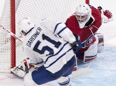 Toronto Maple Leafs' Jake Gardiner, left, scores past Montreal Canadiens goaltender Zachary Fucale during overtime NHL pre-season hockey action Tuesday, September 22, 2015, in Montreal. The Leas beat the Canadiens 2-1.