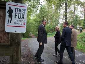 Former MP James Moore, from left to right, Prime Minister Stephen Harper's wife, Laureen Harper, and local Conservative candidates Tim Laidler and Doug Horne leave after a photo opportunity on the training route Terry Fox used while preparing for his cross-country run, in Port Moody, B.C., on Sunday September 20, 2015.