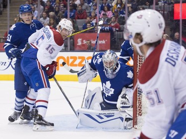 Toronto Maple Leafs goaltender James Reimer, second from right, watches the puck as teammate Jake Gardiner, left, tries to clear Montreal Canadiens forward Tomas Fleischmann from the crease during first period pre-season exhibition NHL hockey action in Toronto on Saturday, September 26, 2015.