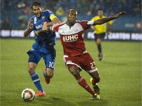 Montreal Impact's Ignacio Piatti and New England Revolution's Jose Goncalves battle for the ball during first half MLS action in Montreal on Saturday, Sept. 19, 2015.