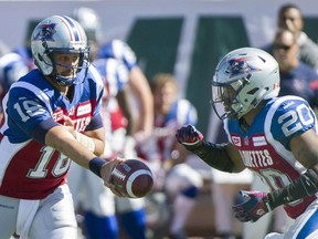 Montreal Alouettes' quarterback Jonathan Crompton, left, hands off to Tyrell Sutton during first half CFL football action against the Winnipeg Blue Bombers in Montreal, Sunday, Sept. 20, 2015.