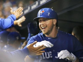 Toronto Blue Jays' Justin Smoak celebrates with teammates in the dugout after hitting a first-inning, two-run, home run in a baseball game against the New York Yankees at Yankee Stadium in New York, Friday, Sept. 11, 2015.