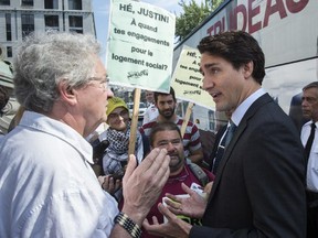 Liberal Leader Justin Trudeau talks with Francois Saillant, a social housing activist, as he arrives at Montreal City Hall, Sept. 3, 2015.
