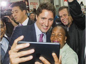 Liberal leader Justin Trudeau poses for a photograph with a supporter following an event to officially open his 2015 federal election campaign office in the riding of Papineau in Montreal Tuesday, August 11, 2015.