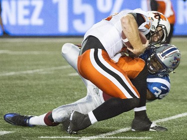 B.C. Lions' quarterback Travis Lulay, left, is tackled by Montreal Alouettes' Kyries Hebert during first half CFL football action in Montreal on Thursday, September 3, 2015.