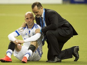 Impact defender Laurent Ciman is consoled by team president Joey Saputo after losing 4-2 to Mexico's Club America in CONCACAF Champions League final on April 29, 2015 at Montreal's Olympic Stadium.