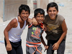 Syrian refugee children pose for a photo at an unofficial refugee camp in the northern Lebanese city of Tripoli, north of the capital Beirut, on September 2, 2015.