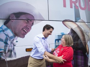 Liberal leader Justin Trudeau jokes around with the lady whose picture is on the side of his campaign bus during an event in Amherst, N.S., on Tuesday, September, 8, 2015.