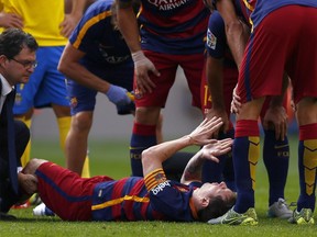 FC Barcelona's Lionel Messi, from Argentina, reacts after being injured,  during a Spanish La Liga soccer match against Las Palmas at the Camp Nou stadium in Barcelona, Spain, Saturday, Sept. 26, 2015.
