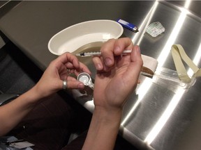 A client administers drugs at Insite, a safe injection site in Vancouver.