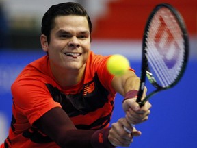 Milos Raonic of Canada returns the ball to Roberto Bautista of Spain during the St. Petersburg Open ATP tennis tournament semifinal match in St.Petersburg, Russia, Saturday, Sept. 26, 2015.