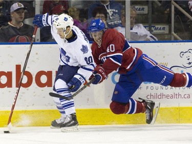 Montreal Canadiens forward Connor Crisp trips as he tails Toronto Maple Leafs defenceman Nikolas Brouillard behind the Leafs' net during their NHL Rookie Tournament hockey game at Budweiser Gardens in London, Ont., on Saturday, September 12, 2015.